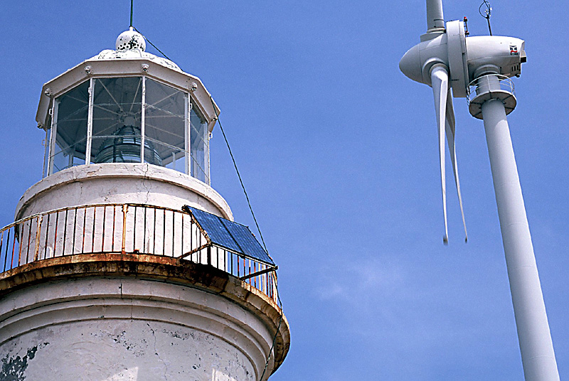 [Photo of Megawatt Scale Grid-Connected Enercon Wind Turbine in front of Small PV power System for Lighthouse, on island of Bozcaada, Turkey.]